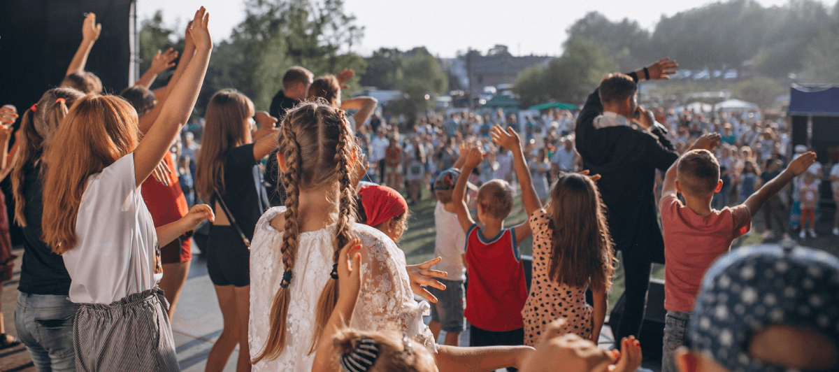 enfants levant les bras sur la scène d'un concert